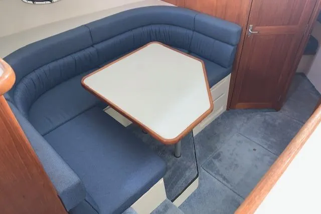 Slide: The Image of 1995 Carver 370 Aft Cabin interior with blue seating and wooden table. - 16