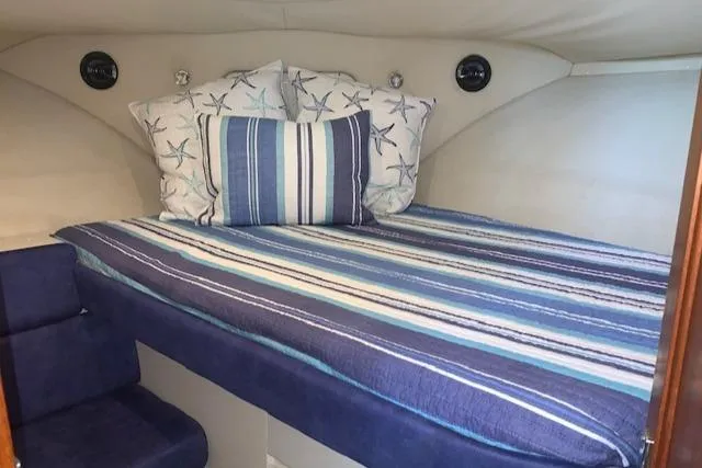 Slide: The Image of 1995 Carver 370 Aft Cabin interior with striped bedding and decorative pillows. - 18