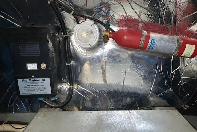 Slide: The Image of Engine room of 1995 Carver 370 Aft Cabin with fire extinguisher and Pro Mariner 30 charger. - 26