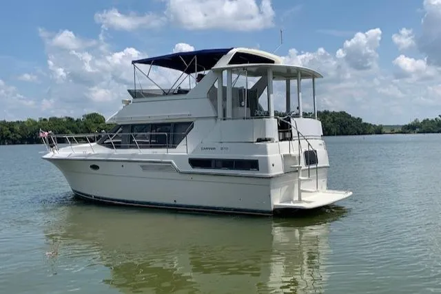 Slide: The Image of 1995 Carver 370 Aft Cabin yacht on calm water under a blue sky. - 5