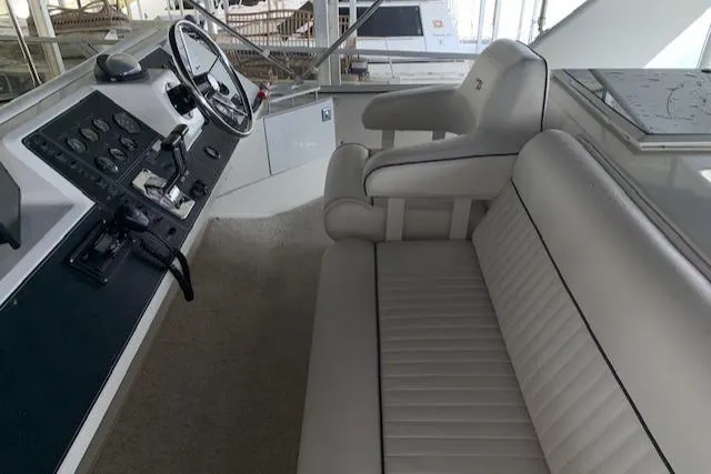 Slide: The Image of 1995 Carver 370 Aft Cabin helm with white seating and control panel. - 8