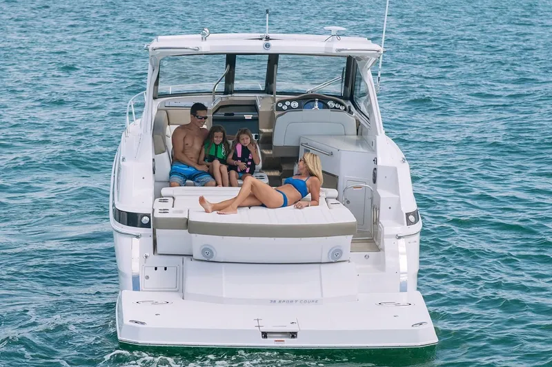 Slide: The Image of 2019 Regal 35 Sport Coupe on the water with family relaxing on deck. - 45