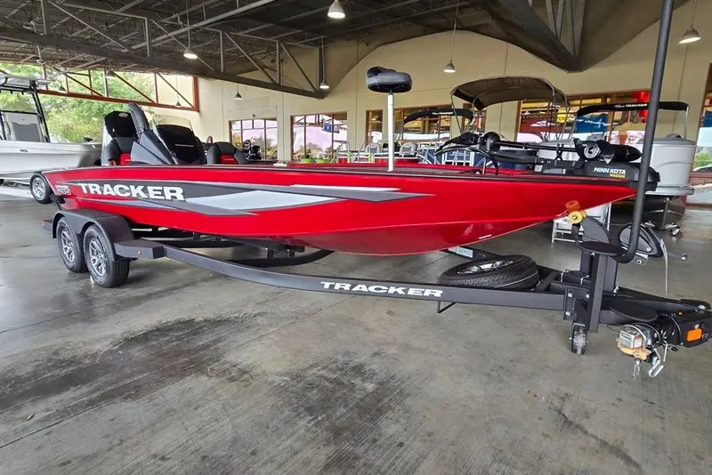 The Image of 2025 Tracker Savage 215 boat in showroom, vibrant red color, on a trailer. - 0