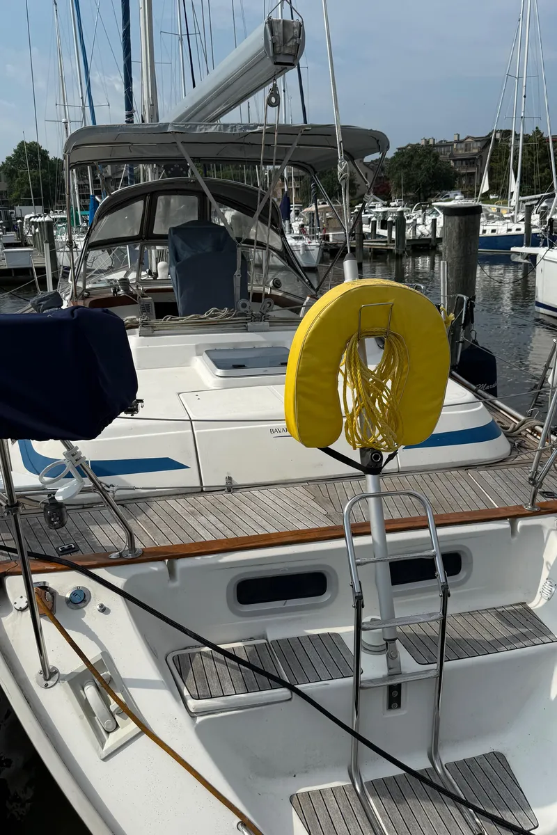 Slide: The Image of Sailboat Bavaria 42 Ocean 1999 docked at marina, featuring a yellow life ring. - 2