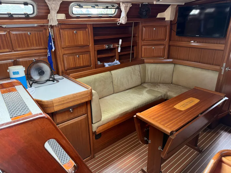 Slide: The Image of Interior of 1999 Bavaria 42 Ocean yacht with wooden furnishings and cozy seating area. - 21
