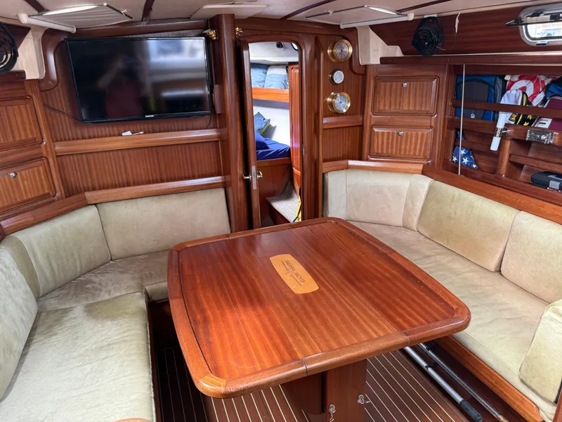 Slide: The Image of Interior of 1999 Bavaria 42 Ocean yacht with wooden table and cushioned seating. - 23