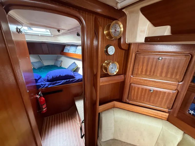 Slide: The Image of Cozy cabin interior of 1999 Bavaria 42 Ocean yacht with wooden finish and blue bedding. - 24