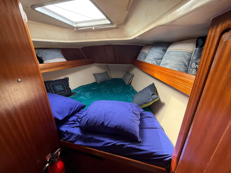 Slide: The Image of Cozy cabin interior of 1999 Bavaria 42 Ocean yacht with blue bedding and wooden accents. - 25