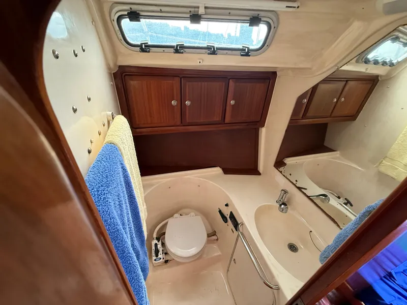 Slide: The Image of Interior of 1999 Bavaria 42 Ocean yacht bathroom with wooden cabinets and porthole window. - 26