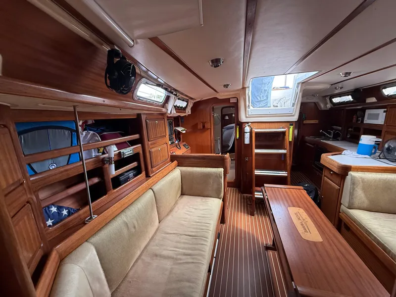 Slide: The Image of Interior of 1999 Bavaria 42 Ocean yacht with wooden furnishings and cozy seating. - 27