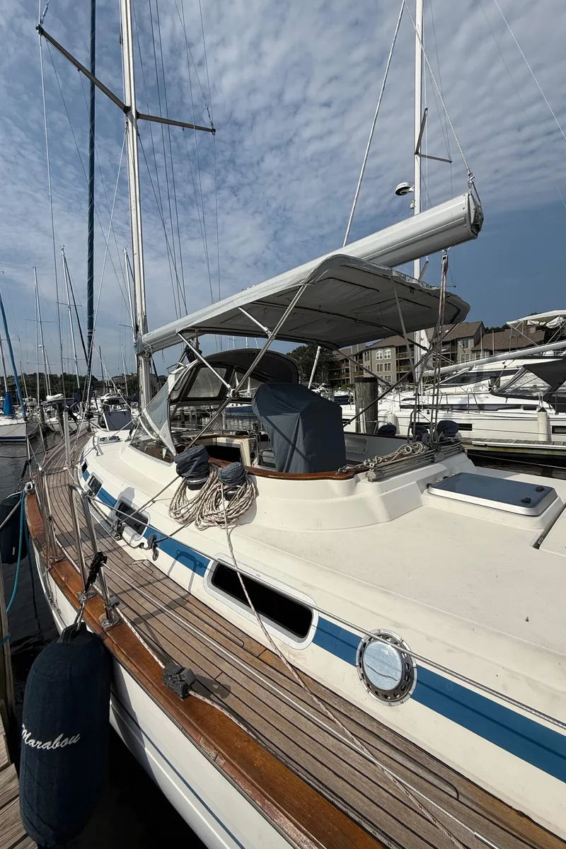 Slide: The Image of 1999 Bavaria 42 Ocean sailboat docked at marina under a cloudy sky. - 3