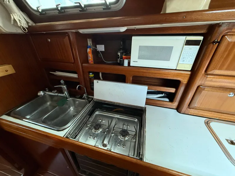 Slide: The Image of Galley kitchen in 1999 Bavaria 42 Ocean yacht with sink, stove, and microwave. - 32