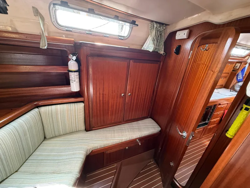 Slide: The Image of Interior of 1999 Bavaria 42 Ocean yacht with wooden cabinetry and striped seating. - 36