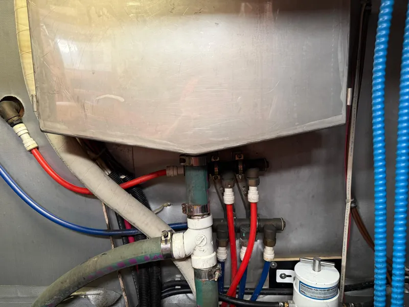 Slide: The Image of Engine compartment of a 1999 Bavaria 42 Ocean yacht with visible hoses and connections. - 41