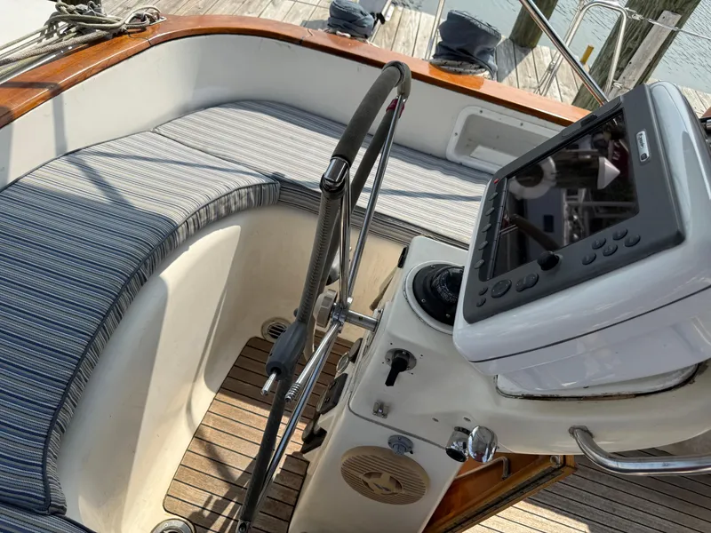 Slide: The Image of Cockpit of 1999 Bavaria 42 Ocean sailboat with striped cushions and navigation equipment. - 6
