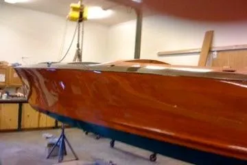 Slide: The Image of 1931 Hacker-Craft 26 Dolphin boat in workshop, showcasing polished wooden hull. - 102