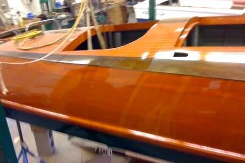 Slide: The Image of 1931 Hacker-Craft 26 Dolphin boat with polished wooden finish in workshop setting. - 128