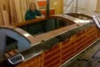 Slide: The Image of 1931 Hacker-Craft 26 Dolphin boat with wooden finish in a workshop setting. - 143