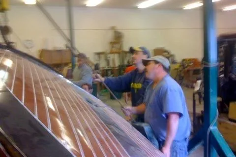 Slide: The Image of Workers restoring a 1931 Hacker-Craft 26 Dolphin boat in a workshop. - 160