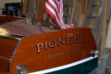 Slide: The Image of 1931 Hacker-Craft 26 Dolphin boat with "Pioneer" name and American flag. - 168