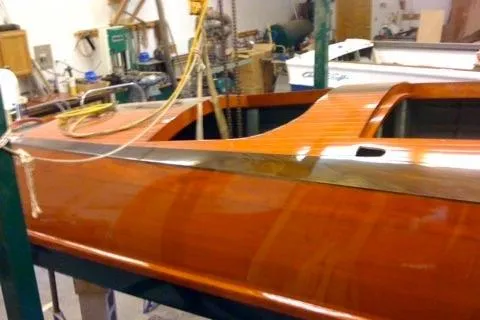 Slide: The Image of 1931 Hacker-Craft 26 Dolphin boat with polished wooden finish in a workshop setting. - 187