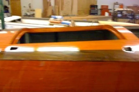 Slide: The Image of 1931 Hacker-Craft 26 Dolphin boat with polished wood finish in a workshop setting. - 190
