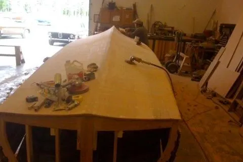 Slide: The Image of Restoration of a 1931 Hacker-Craft 26 Dolphin boat in a workshop setting. - 250