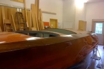 Slide: The Image of 1931 Hacker-Craft 26 Dolphin boat in workshop, showcasing polished wooden hull. - 66