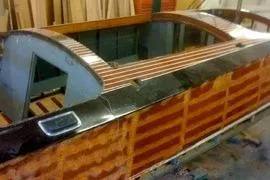 Slide: The Image of 1931 Hacker-Craft 26 Dolphin boat with polished wood finish in a workshop. - 72