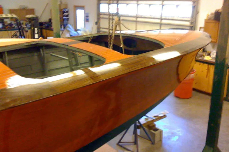 Slide: The Image of 1931 Hacker-Craft 26 Dolphin boat in a workshop, showcasing polished wooden finish. - 82