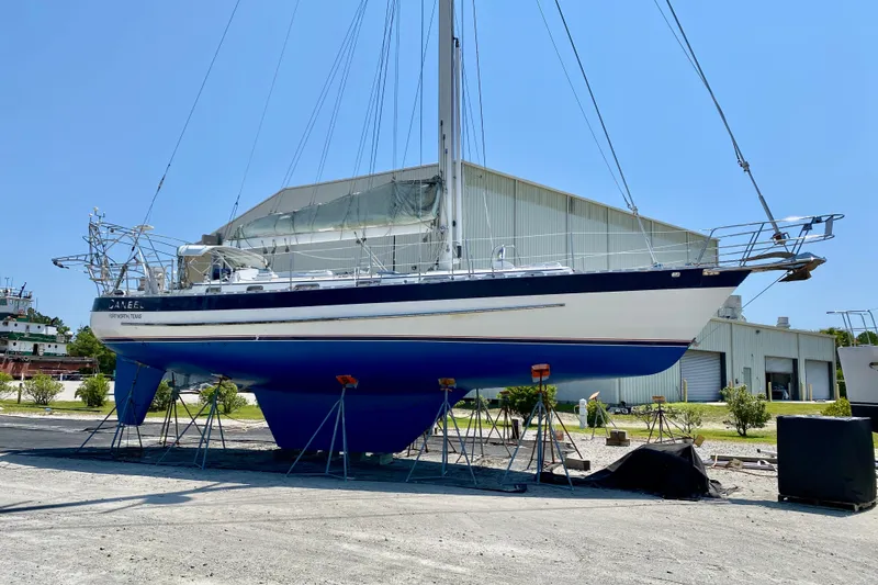 The Image of Valiant 50 sailboat from 2007 on stands, outside a large industrial building. - 0