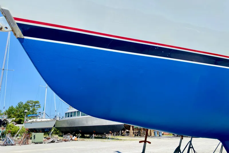 Slide: The Image of Valiant 50 sailboat, 2007 model, with vibrant blue hull in a boatyard setting. - 2