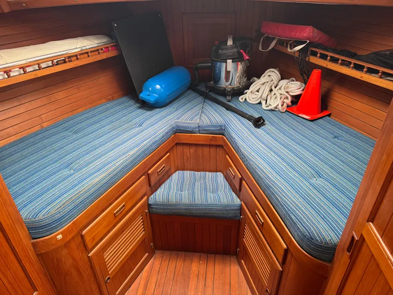 Slide: The Image of 1984 Monk 36 Trawler cabin with blue cushions, wooden interior, and nautical equipment. - 12