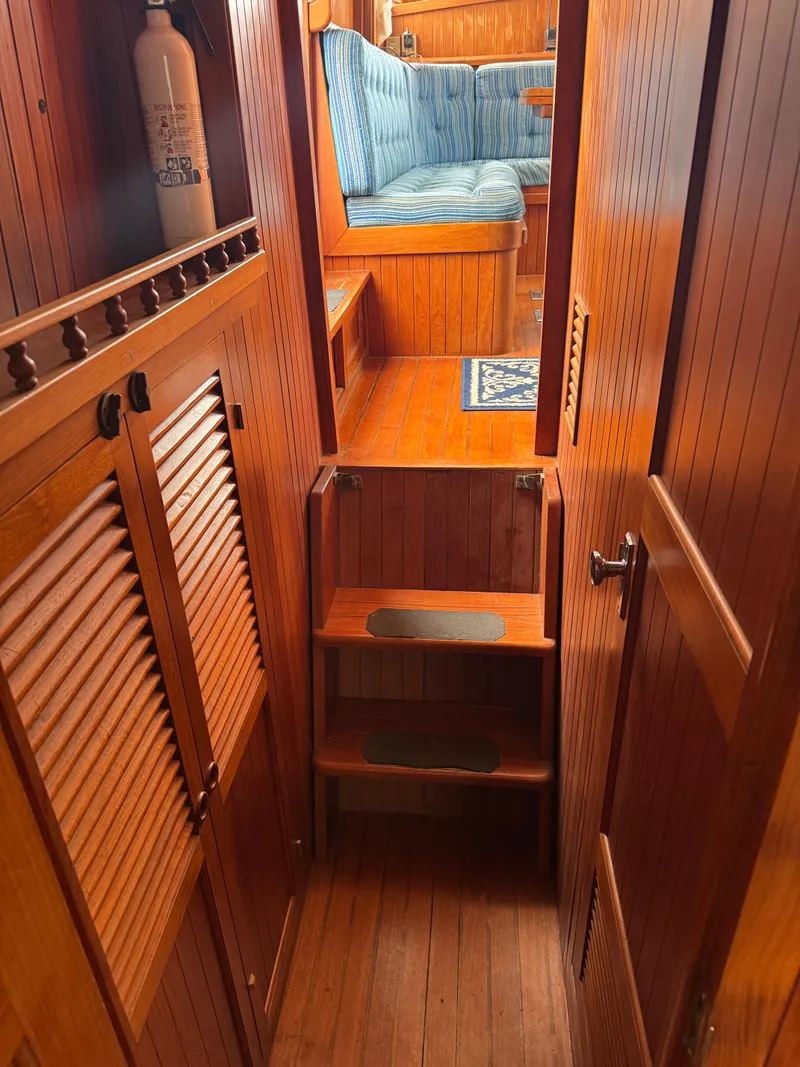 Slide: The Image of 1984 Monk 36 Trawler interior with wooden paneling and blue cushioned seating. - 13