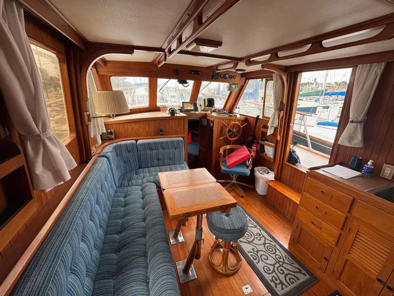 Slide: The Image of Interior of 1984 Monk 36 Trawler with wood paneling, blue seating, and nautical decor. - 14