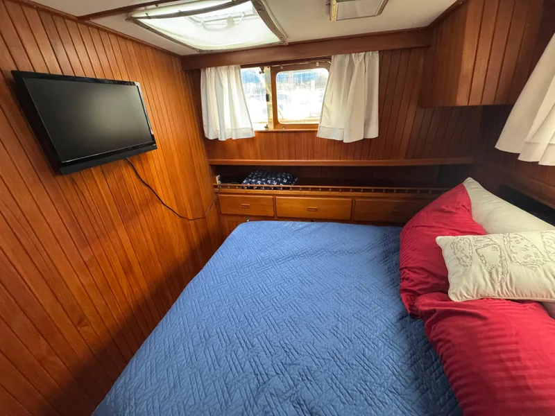 Slide: The Image of Cozy cabin interior of 1984 Monk 36 Trawler with wood paneling and bed. - 22
