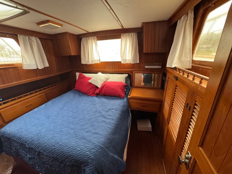 Slide: The Image of Cozy cabin interior of 1984 Monk 36 Trawler with wood paneling and a comfortable bed. - 23