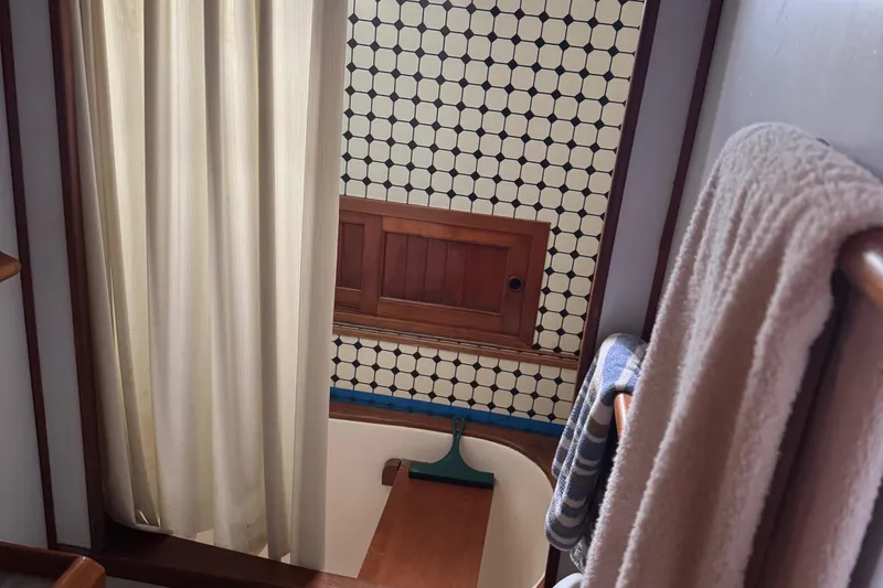 Slide: The Image of Interior of 1984 Monk 36 Trawler bathroom with curtain, towels, and patterned wall tiles. - 25