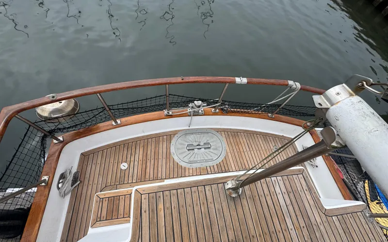 Slide: The Image of 1984 Monk 36 Trawler deck with wooden finish and metal railings by the water. - 4