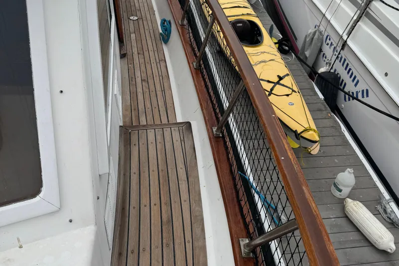 Slide: The Image of Wooden deck of 1984 Monk 36 Trawler with kayak and docked boats. - 9