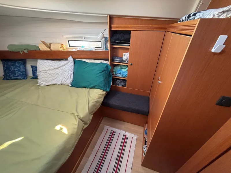 Slide: The Image of Cozy cabin interior of 2014 Bavaria 36 Cruiser with bed, pillows, and wooden storage. - 17