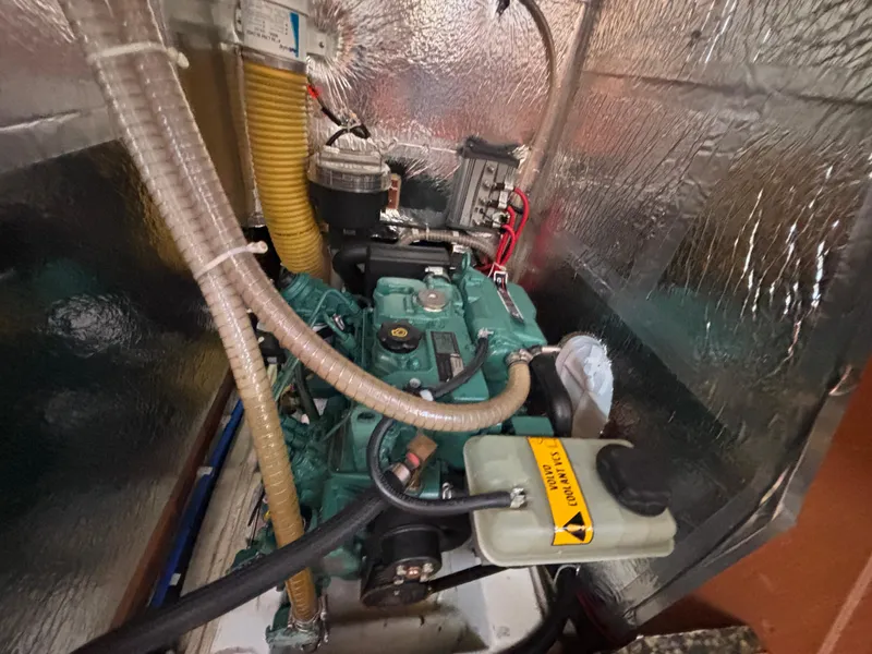 Slide: The Image of Engine compartment of a 2014 Bavaria 36 Cruiser sailboat, featuring insulated walls and hoses. - 19