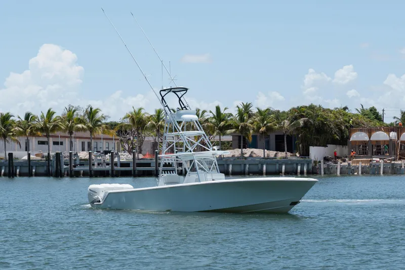 Slide: The Image of 2017 SeaVee Z39 boat cruising near palm-lined shore under clear sky. - 2