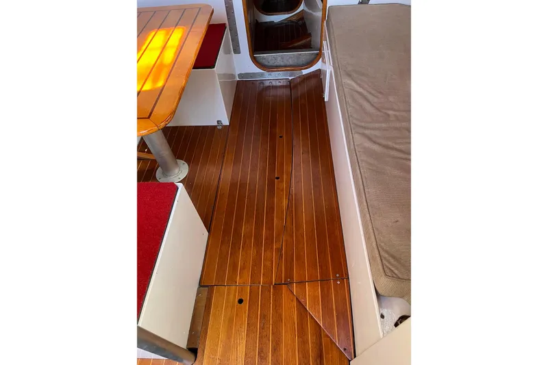 Slide: The Image of Interior of 1976 Custom C&B Marine boat with wooden flooring and seating area. - 10