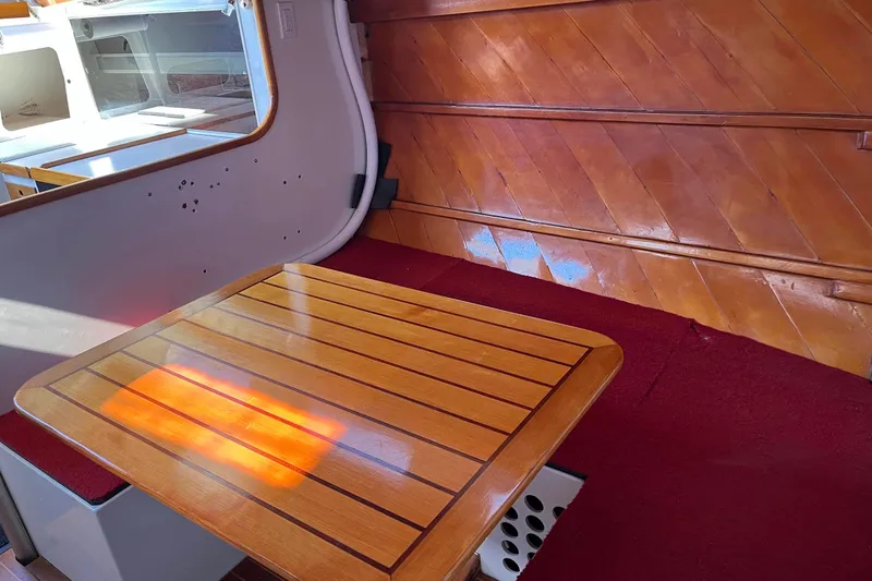 Slide: The Image of 1976 Custom C&B Marine interior with wooden table and red carpet. - 7