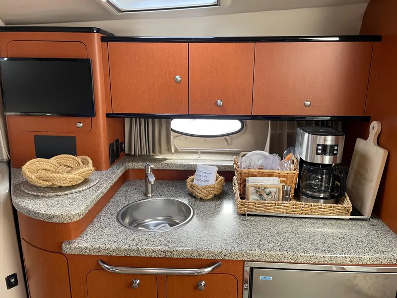 Slide: The Image of 2005 Chaparral Signature 330 kitchen with sink, coffee maker, and storage cabinets. - 11
