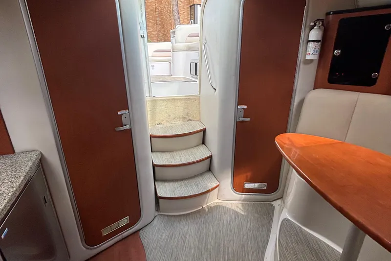 Slide: The Image of Interior of 2005 Chaparral Signature 330 boat, featuring stairs and wooden accents. - 15