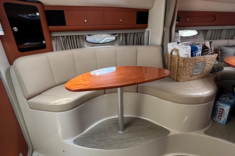 Slide: The Image of Interior of 2005 Chaparral Signature 330 yacht with beige seating and wooden table. - 19
