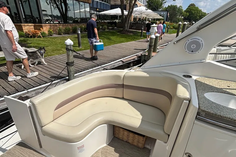 Slide: The Image of 2005 Chaparral Signature 330 boat with beige seating, docked near a boardwalk. - 3