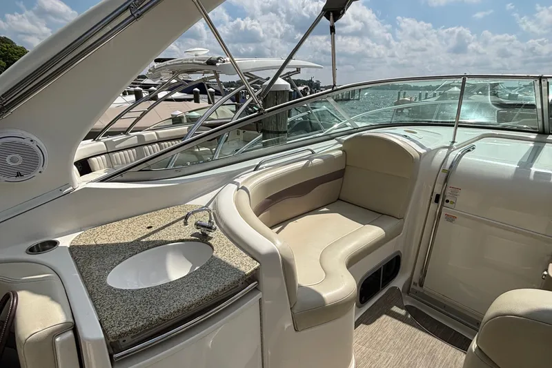 Slide: The Image of 2005 Chaparral Signature 330 boat interior with seating and sink, under a sunny sky. - 5